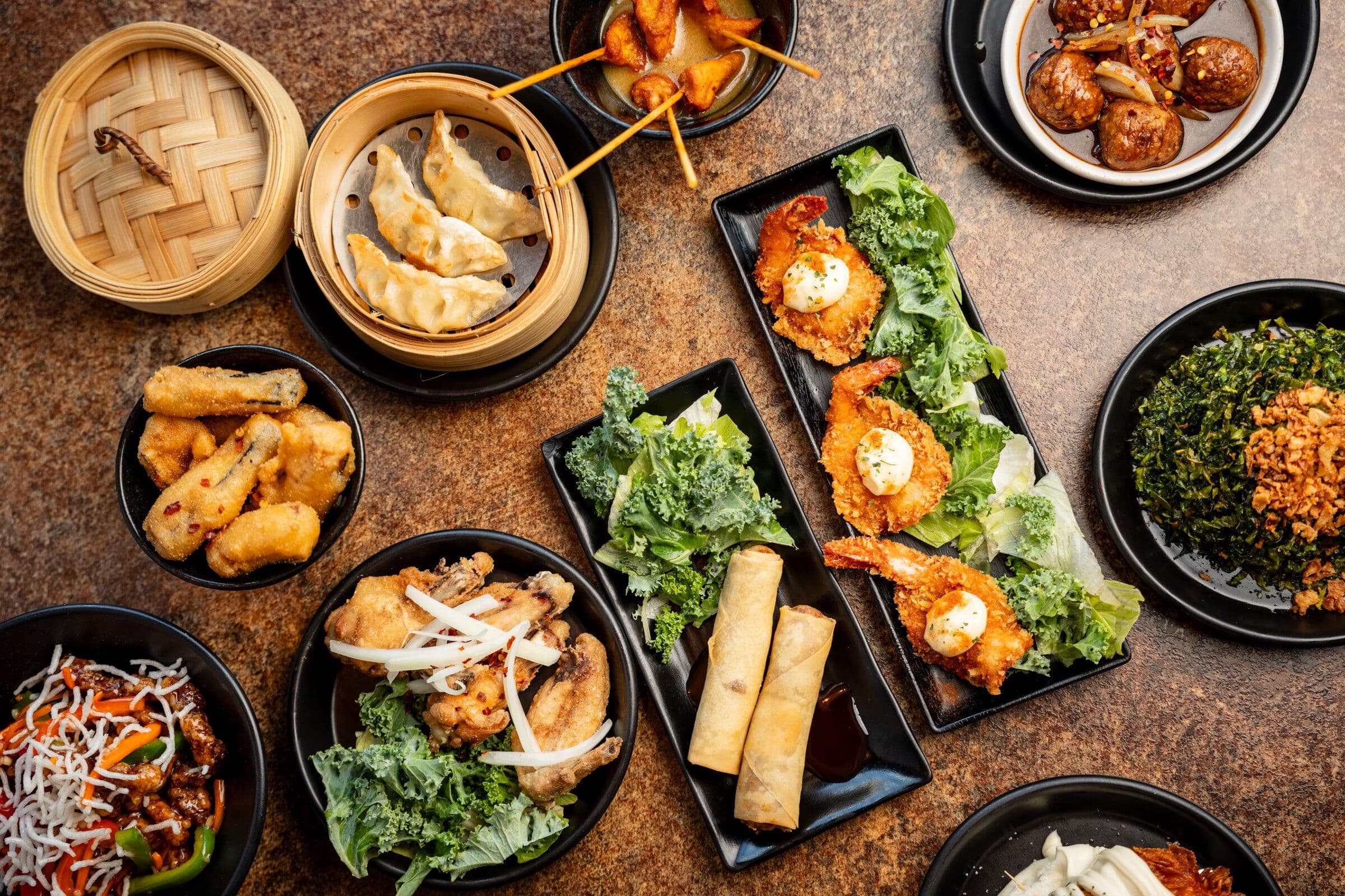 A table of shared Taste Social plates - dumplings, rice and ribs